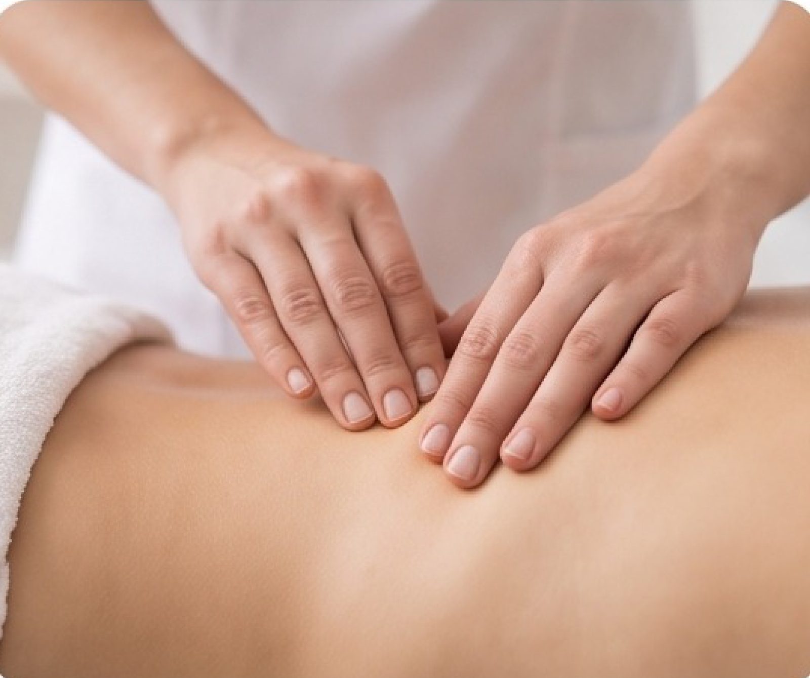 Mains de la thérapeute effectuant une technique myofasciale douce sur le dos